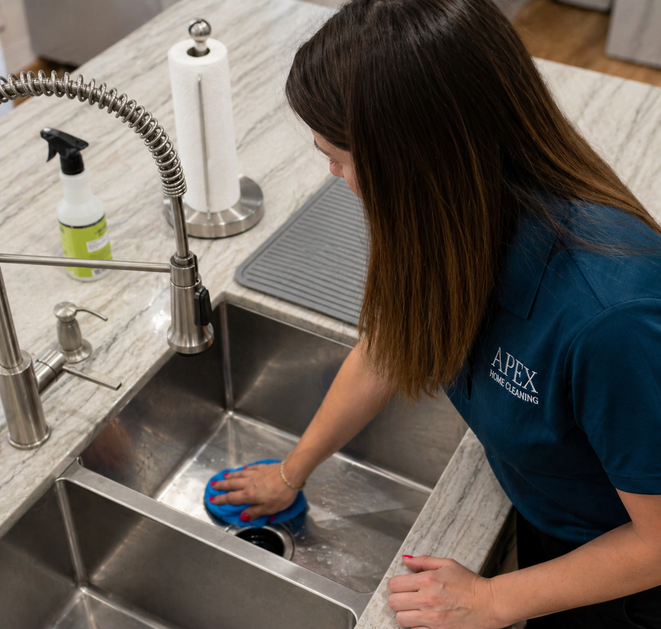 Apex Home Cleaning professional scrubbing a kitchen sink during a Canyon Lake Airbnb turnover