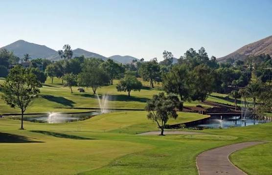 Canyon Lake golf course with fountains, green fairways, and hills in the background