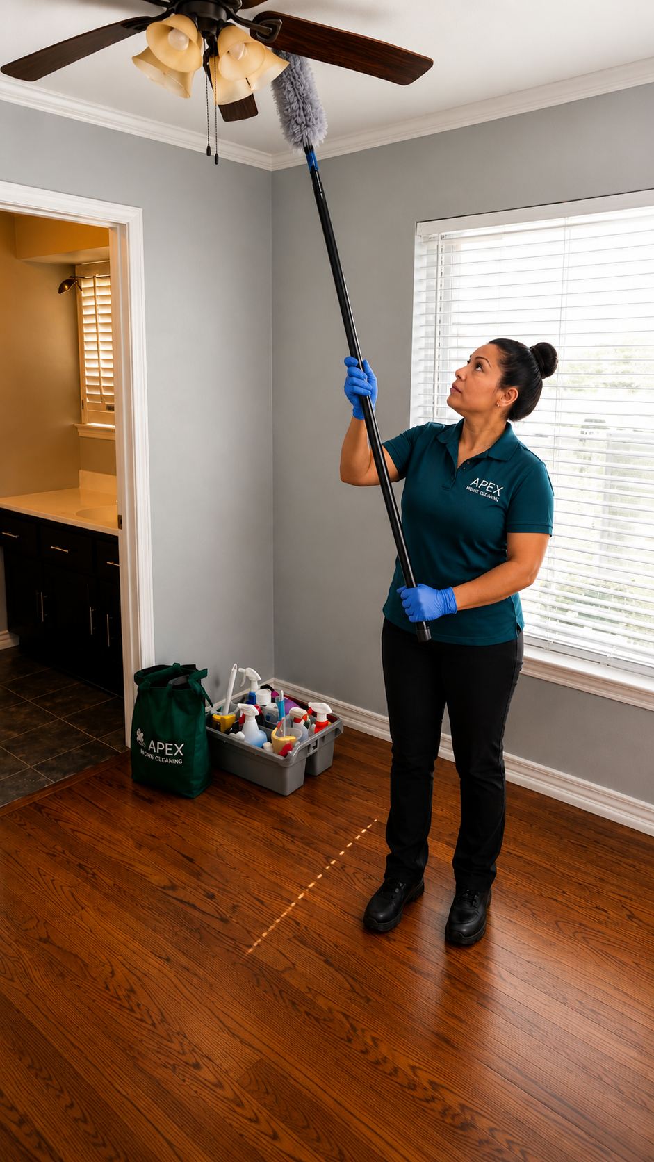 Apex Home Cleaning professional wiping down a window sill and ledge overlooking a green Lake Elsinore backyard
