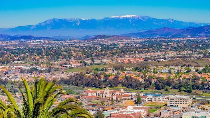 Aerial view of French Valley, California with rooftops and mountains in the distance