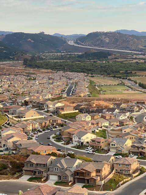 Hillside view over Fallbrook, California — neighborhoods and avocado groves set among the rolling hills