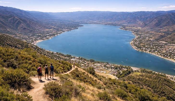 Hikers overlooking the lake and Ortega Mountains in Lake Elsinore, California