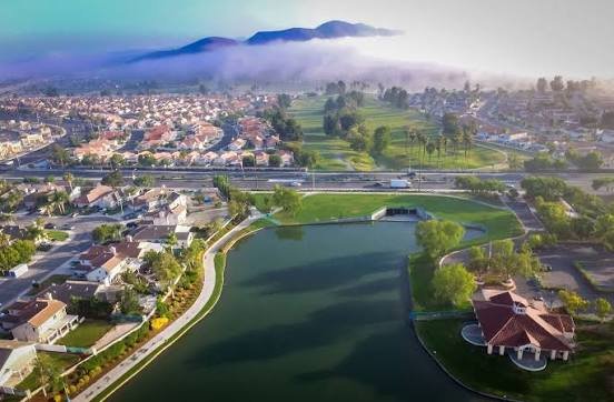 Aerial view of Menifee, California neighborhoods, lake and golf course at sunrise