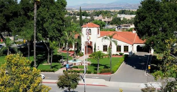 Historic Perris City Hall with palm trees and mountains in the background
