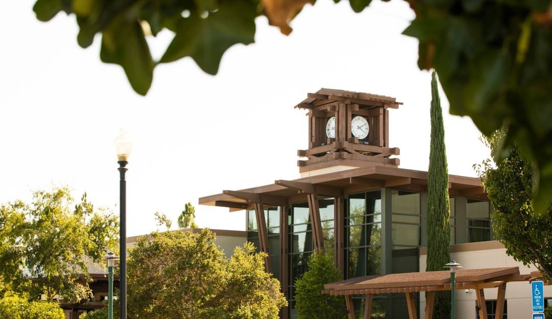 The clock tower at Murrieta Town Square framed by trees
