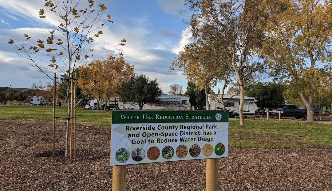 A Riverside County Regional Park sign at a Murrieta-area park with autumn trees