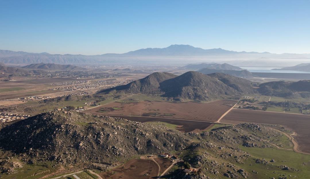 An aerial view of the hills and valleys around Murrieta with mountains in the distance