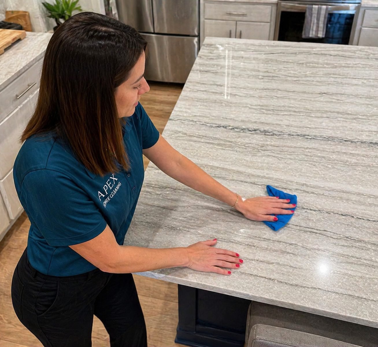 Apex professional wiping down a marble kitchen island in a Perris home