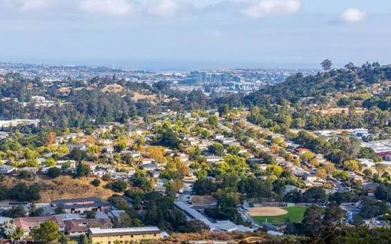 An aerial view of tree-filled residential neighborhoods nestled in the rolling hills near Winchester, California