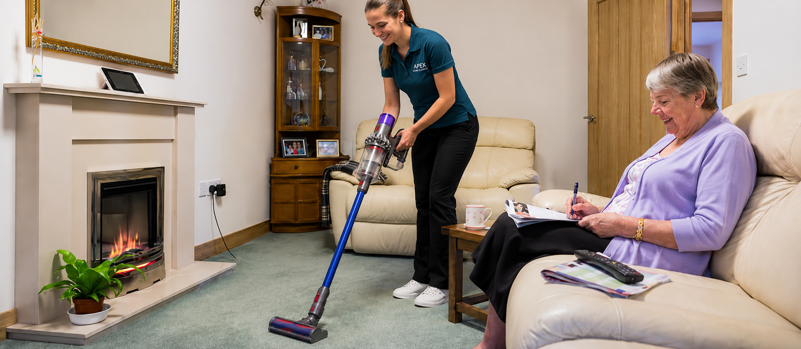 Apex pro vacuuming the living room while a senior client relaxes at home in Menifee